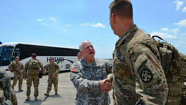 Brig. Gen. Charles Gable, center, welcomes a member of the Alabama Army National Guard shortly after the soldiers landed in Gulfport, Miss., on May 8. (Contributed)
