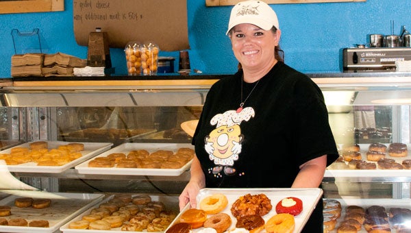 Jennifer Gardener shows off a tray of best-selling donuts. For a fun twist at Donut Chef, order up your own personal donut composed from their selection of 10 fillings, 10 toppings and seven icings, including Fruity Pebbles, Reese Cups or Gummi Bears! (contributed)
