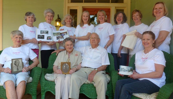 The Parkman cousins holding family memorabilia on the front porch of the Columbiana Inn. Front row, Frances Soukup, Helen Land,  James Land and Judy Land West. Back row: Melanie Howard, Alice Overton, Apphia Woods, Ann Parkman, Ethel Fern, Jean Lufkin Bouler, Diane Hett and Marian Fletcher.  (contributed)