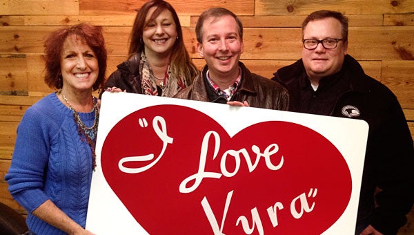 Arts Council members Monica Josephson, Mandy Delcambre, Tim Wolfe and Hal Woodman show off the first sign completed for the Valentine’s Day greetings project. (contributed)