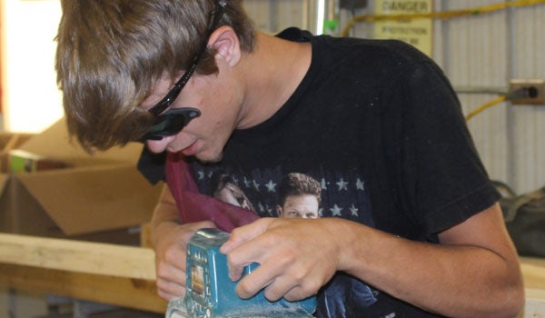 A SCCC student uses a belt sander to smooth the track he is helping to build for the Belt Sander Race. (Contributed)