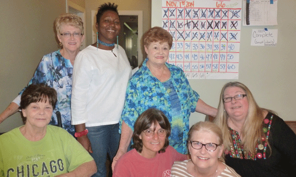 Quilt of Valor Alabama Director Elizabeth Mathews in the quilting room at Magnolia Retreat in Odenville in front of the Wilsonville QOV countdown calendar with volunteer QOV quilters: back row: Carol Rayfield (Moody); Barbara Willingham (Moody); Clydene Dyer (Branchville); Amy Jett (Eastaboga); and front row: Evelyn Milligan (Odenville); Mathews; and Janice Long (Chelsea.) (Contributed)
