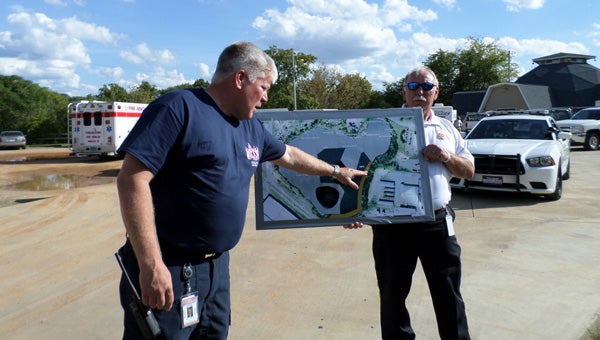 Pelham Fire Department Deputy Chief Blair Sides points to areas of the quarry that have been searched on a map held by Pelham Fire Department Chief Danny Ray. The lighter areas of the map have all been searched, Sides confirmed. (Reporter Photo / Molly Davidson)