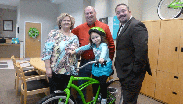  Janie and Fred Nichols of Summerhill with granddaughter Marilyn (4) on the Regions bike that Nichols won from the Monster Walk drawing. Also pictured is Columbiana Branch Manager Jimmy Henderson, far right. (Contributed)