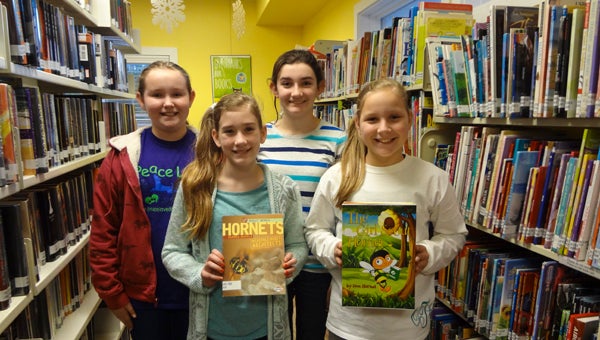 Girl Scout Troop 33590 members Ella Harris, Bella Roshaven, Brooke Jones and Olivia Trout display the letterbox and children's book they planted in the Chelsea Public Library. (Reporter Photo/Emily Sparacino