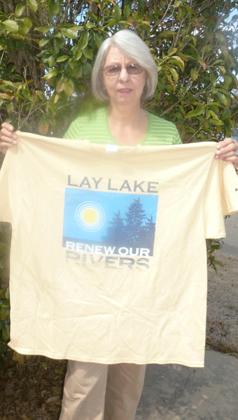 Lay Lake HOBO Cleanup Chair Judy Jones holding the 2015 T-shirt provided by Alabama Power to cleanup volunteers at the picnic at Beeswax Park on April 18 at noon. Jones has been the cleanup chair for the last 17 years, since its inception in 1999. 