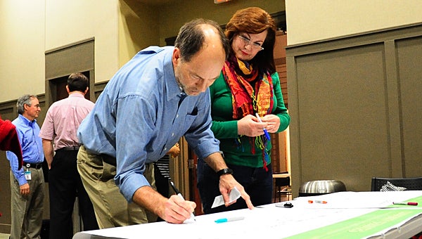 Tom Bunch and his wife, Lanie, write their goals for the city's future on a poster during a March 10 comprehensive planning meeting at Alabaster City Hall. (Reporter Photo/Neal Wagner)