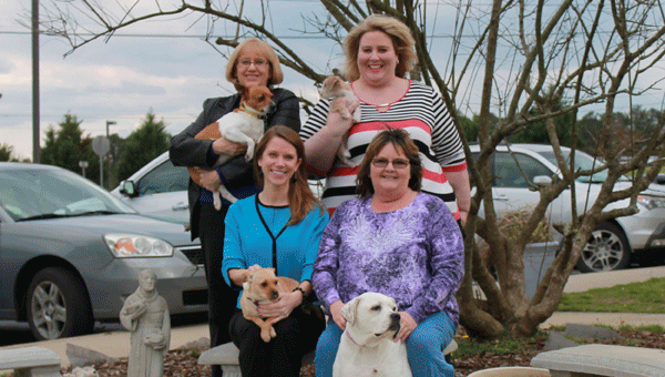 Front row: The Best Friends of Shelby Humane Society Co-Chair Lacey Bacchus, Shelby County Humane Society Executive Director Sara Shirley; back row: BFoSHS member Linda McCartney and Co-Chair Stephanie Clayton sit at the Eagle Scout outdoor renovation project holding pets who need adoption at the Shelby Humane Society. (Contributed)