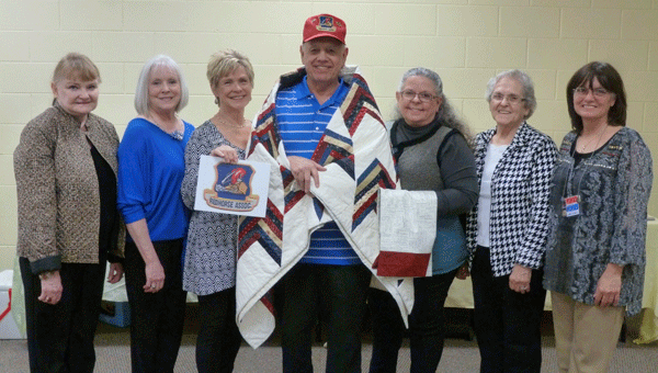 Air Force Veteran Bill Ackley was honored for his years of service with his Quilt of Valor at the DAR David Lindsay Chapter meeting. Pictured are DAR Daughter and QOV quilter Linda Giddens, QOV quilter Judi Elliott, wife Linda Ackley holding the Red Horse emblem Ackley designed, Ackley covered with his QOV, DAR Daughter and QOV quilter and coordinator Lura Johnson Campbell, DAR Daughter and QOV Caroline Johnson, and Founding Alabama Quilt of Valor Coordinator Elizabeth Mathews who presented the quilt and QOV program. Not pictured are quilters Duffy Morrison, Karen Jensen and Shelby Looney. (Contributed)