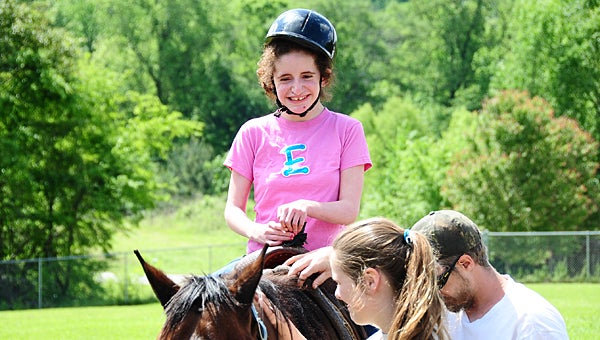 Linda Nolen Learning Center student Ellie Meeks is all smiles as volunteers from the Montevallo-based Carousel O’Breeds Farm lead her on a horse ride on April 29. (Reporter Photo/Neal Wagner)