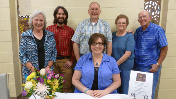 Columbiana native Olivia Folmar Ard (sitting) was honored at a reception and book signing sponsored by the Friends of the Columbiana Public Library spotlighting her new novel "The Partition of Africa." Pictured with Ard are grandmother Gayle Folmar Ard, husband John Ard, father Damon Folmar and grandparents Marie and Bob Hartley.
