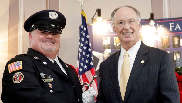 U.S. Marine Corps Veteran James Quakenbush volunteers with Bugles Across America, the non-profit organization that provide free "live" music of Taps by volunteer musicians at military funerals. Pictured are Quakenbush with Gov. Robert Bentley at the Wreaths Across America at the State House in Montgomery in December 2014. (Contributed)
