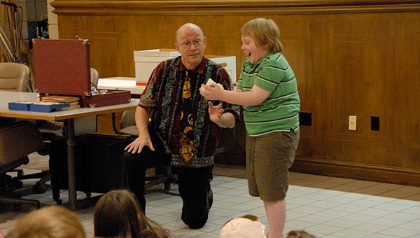 Magician Russell Davis wows Seth Hamilton with one of his magic tricks at the Helena Summer Reading Program held at Helena City Hall on Wednesday, June 24. (Reporter Photo/Graham Brooks)