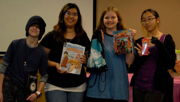 Manga Book Club members Dakota Brown, Steph, Rachel Danielson and Putt Putt show off some of their manga and anime gear. (Reporter photo / Jessa Pease)