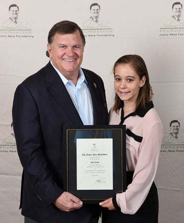 Presenting Kyla Kugler, right, with a Jimmy Rane Foundation scholarship award is the organization’s founder, Jimmy Rane. Kugler accepted the award during the Foundation’s annual charity golf tournament in Montgomery on May 14. (Contributed)