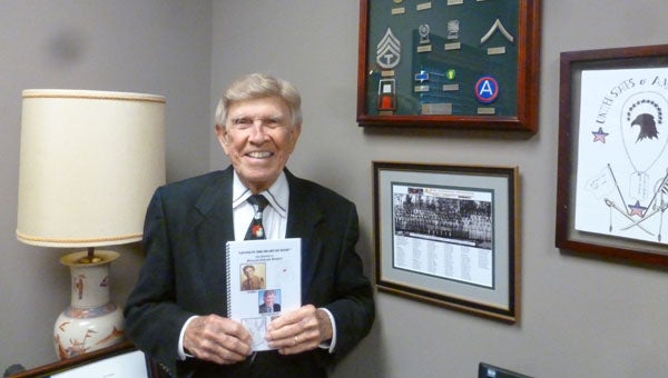 Technical Sergeant William Edward "Bill" Burrus, U.S. Army 1944-1946, fought across Europe into Germany as a infantry rifleman in 87th Infantry Division of General George Patton's Third Army. Burrus is standing in his office on Valleydale Road holding his memoirs next to his Army awards and mementos. (Contributed)