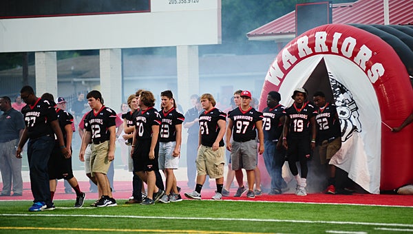 The Thompson High School varsity football team walks onto the field during an Aug. 20 pep rally at Larry Simmons Stadium. (Reporter Photo/Neal Wagner)
