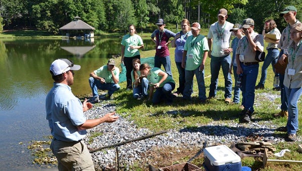 Norm Haley, ACES Forestry, Wildlife and Natural Resources Agent, speaks to the youth and their coaches about pond management and aquatic resources in the Southeast. The Alabama Forestry Commission provided transportation for the educational tour of the Treasure Forest site. (Contributed)