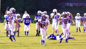 Gabe Griffin crosses the goal line as his teammates celebrate behind him. (For the Reporter / Dawn Harrison)