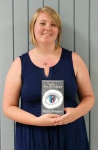 Burrell with her book "The Chronicles of the Secret Society: The End of the Standoff.” (Contributed)
