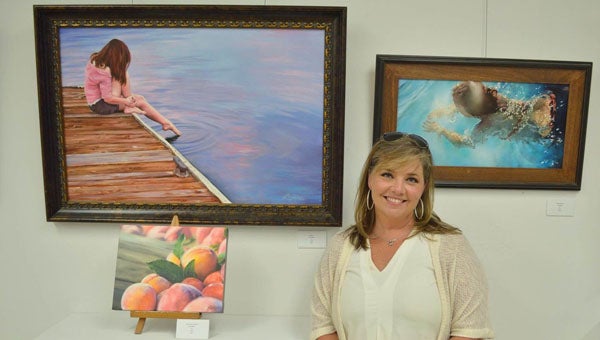 Robin Miller stands with her works in the Shelby County Arts Council's 2015 Juried Art Show during an opening reception on Sept. 10. Miller won Best in Show and Best in Painting awards. (Contributed)
