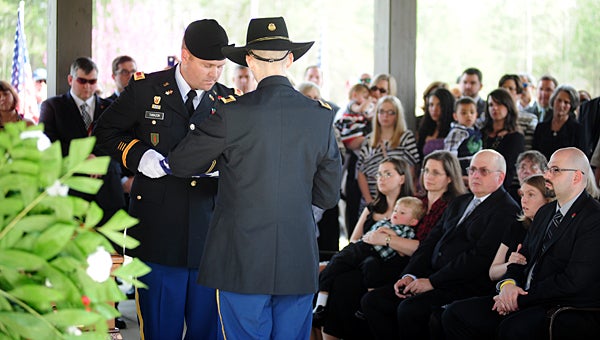 Standing in front of the casket holding Matthew Blount, Troy Tarazon and A.J. Blount fold a flag before presenting it to Blount's wife, Melinda Copeland Blount, during Matthew's burial at the Alabama National Cemetery in Montevallo on March 13, 2012. (File)