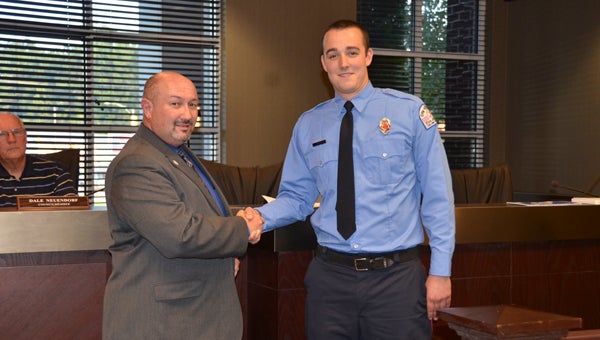 Bert Seitz, right, Chelsea Fire and Rescue's newest full-time firefighter, received his badge from Fire Chief Wayne Shirley, left, during a Chelsea City Council meeting on Sept. 1. (Reporter Photo/Emily Sparacino)