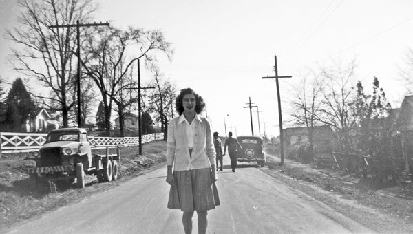 This 1940s photograph shows Mary Jo Lewis posing for Charles Nunnally in the middle of Helena's Main Street. The Dr. Fritz Lubright home can be seen on the left. Dr. Lubright was a popular dentist in Helena from about the time of World War I to the early 1940s and had offices in the mining towns of Marvel and Piper as well. Today the house is the home of Chris and Christina Register. (Contributed/City of Helena Museum)