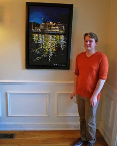 Hoover High School senior Matthew Evans stands next to his award winning acrylic painting. (Reporter Photo / Molly Davidson)