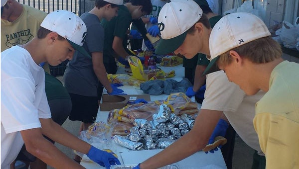 The Pelham High School baseball players cooked, packaged, delivered and served food to the poor and needy in Birmingham Oct. 18 with the Urban Purpose organization. (Contributed) 