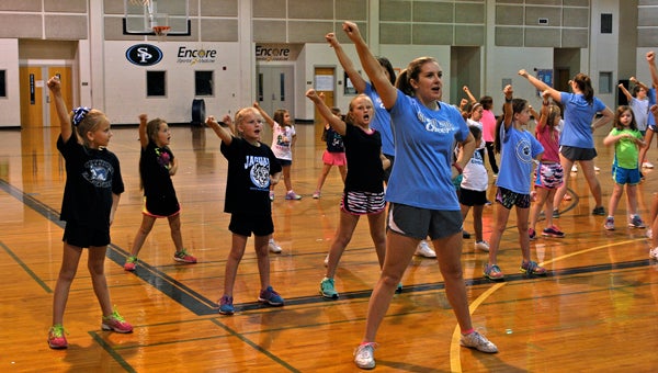 A Spain Park High School cheerleader leads young cheerleaders in a sideline during an Oct. 8 cheer clinic. (Reporter Photo / Molly Davidson)