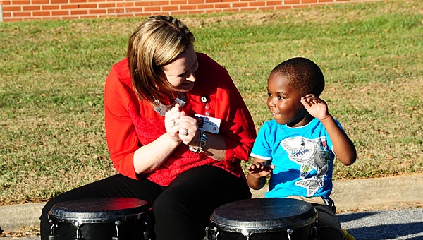 Alabaster City Schools Student Services Coordinator Dorann Tanner, left, watches as Daylen Nabors performs a solo in a drum circle at Kids First in Alabaster on Oct. 22. (Reporter Photo/Neal Wagner)