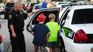 Pelham police officer Michael Morris gives a group of children a look at his patrol car during the National Night Out on Crime event at the Alabaster Target on Oct. 6. (Reporter Photo/Neal Wagner)