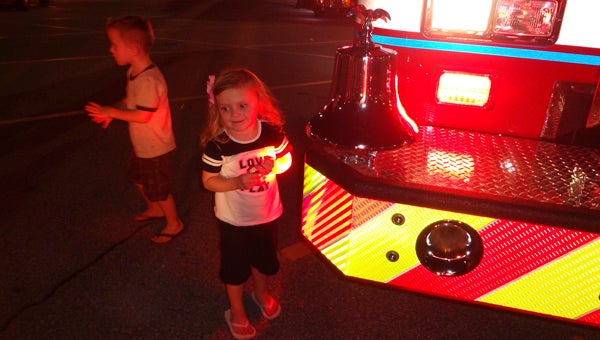 Caylee Bullard of Chelsea approaches a Chelsea fire engine to ring its bell at National Night Out on Oct. 6. Also pictured is Caden Bullard, Caylee's brother. (Reporter Photo/Emily Sparacino)