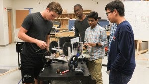 Students make adjustments to their robot, preparing it for the regional level tournament in December. (For the Reporter / Dawn Harrison)
