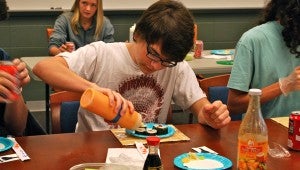 A student adds sauce to this futomaki roll. Students got to eat their creations during the Spain Park High School library's sushi making class on Oct. 7. (Reporter Photo / Molly Davidson)