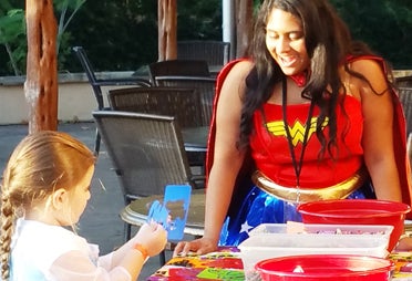Pictured is Senior Mu Alpha Theta President Jessie Harbuck, dressed as Wonder Woman and helping a Boo at the Zoo visitor create a trick-or-treat bag. (Contributed)