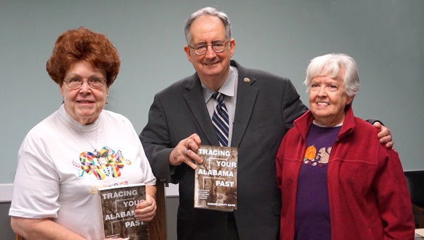 Robert Scott Davis shows his book, "Tracing Your Alabama Past," after his presentation on genealogy. Interested audience members included Ella Bartlett, left, and Virginia Jones. (Contributed)