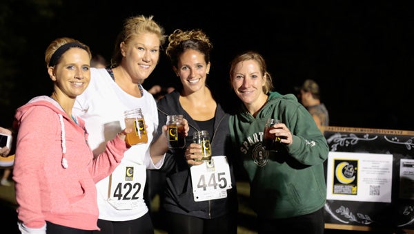 After racing through the dark, participants in the Moonlight Bootlegger 5K enjoy beverages in commemorative mason jar glasses. (Contributed)  
