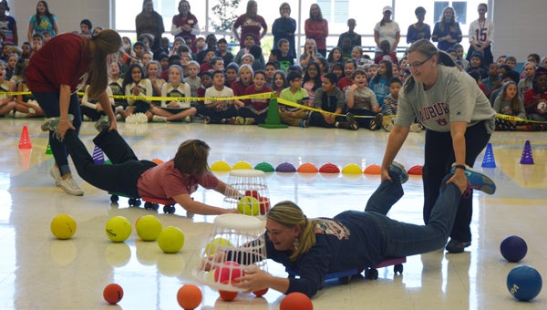 To earn points for either Auburn or Alabama, teachers play Hungry, Hungry Hippos using rollers, foam balls and laundry baskets. (Reporter photo / Jessa Pease) 