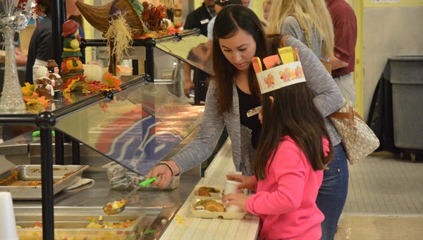 Students at Valley Elementary show their parents how to go through the lunchroom during the school’s annual Thanksgiving Feast. (Reporter photo / Jessa Pease) 