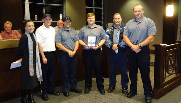 Erin Franklin, left, with the Muscular Dystrophy Association presents Chelsea Fire and Rescue personnel with a plaque in recognition of their fundraising efforts for the 2015 Fill the Boot campaign. (Reporter Photo/Emily Sparacino)