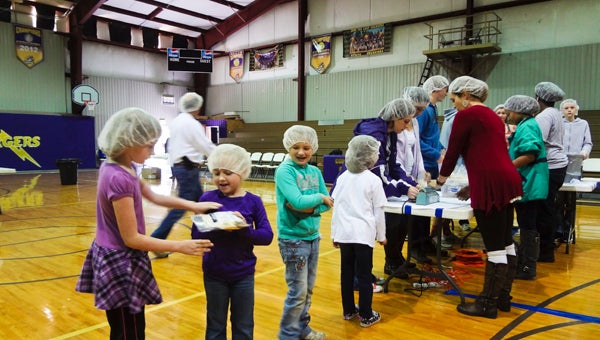 Students at Cornerstone Christian School pass bags of food down the line to be sent to the hungry in Haiti and Shelby County during a Feed the Need event Nov. 13. (Reporter Photo/Emily Sparacino)