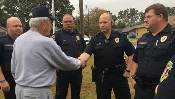Alabaster police officers present U.S. Air Force veteran Thomas Feltman, left, with a new American flag on Nov. 1. (Contributed)