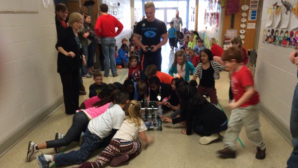 Pelham High School robotics student shows second-graders the VEX robot he and his teammates created. (Contributed) 