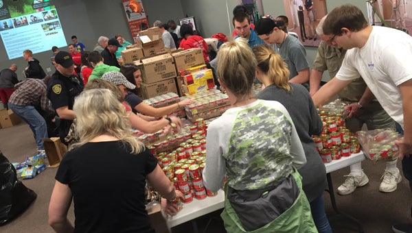 Volunteers pack backpacks full of food to distribute to students in 14 schools who may be at risk for food insecurity. (Contributed)