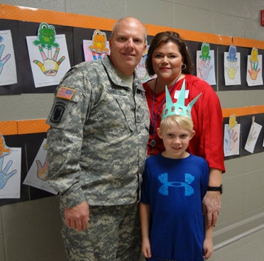 Cooper Chandler, center, honored his father, Mark, left, as a hero during the Liberty Learning Foundation's Super Citizen Program graduation at Forest Oaks Elementary School on Dec. 11. (Reporter Photo/Emily Sparacino)