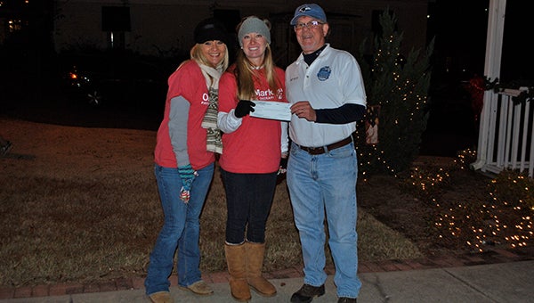 Bob Van Loan of the Helena Business Association presents a check to Jennifer Spencer and Jessica Purvis of OnMark Physical Therapy after announcing them winners of the wreath decorating contest. (Reporter Photo/Graham Brooks)
