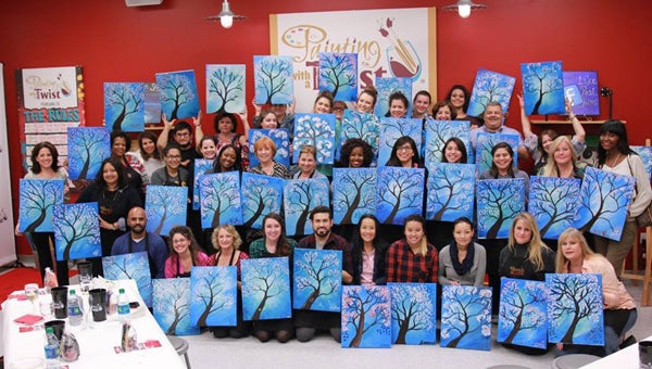 Painters show off their artwork after a session at a Painting with a Twist studio. (Contributed)