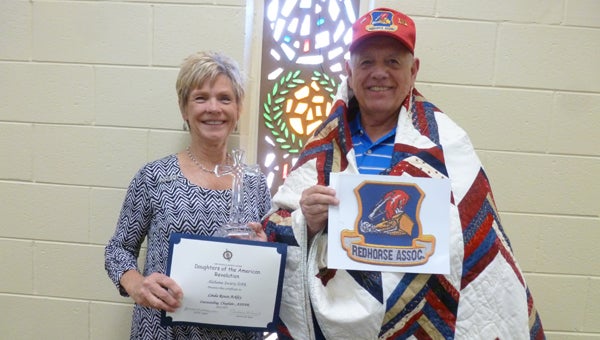 Linda Ackley, member of the David Lindsay Chapter of the American Revolution, won the ASDAR Chaplain of the Year Award for her continuous work to thank all veterans. Pictured are the Ackleys, Linda holding her Chaplain of the Year Award and Bill wearing his Quilt of Valor and holding the Red Horse logo. (Contributed)